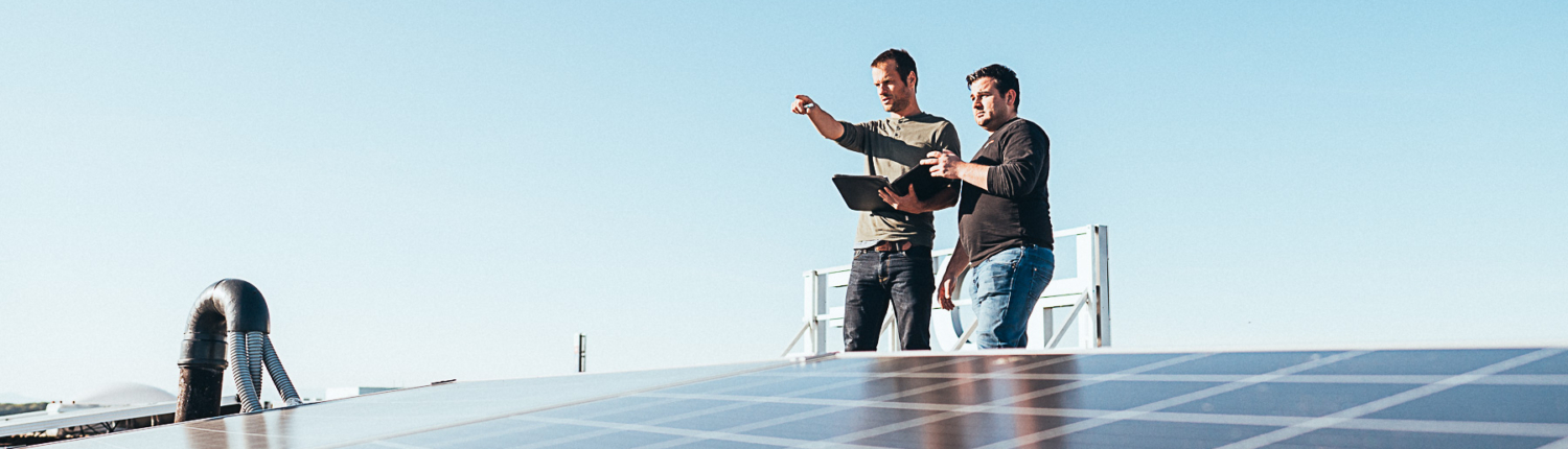 Klimapartner Mitarbeiter auf einem Dach mit viel Photovoltaik